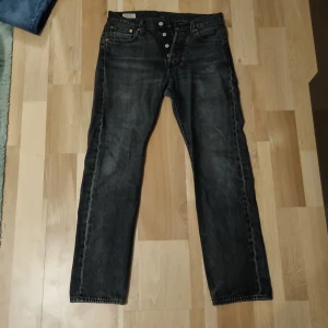 Levi's 501 svarta jeans W28 L30 - Säljer ett par svarta Levi's 501 jeans med klassisk rak passform och knappgylf. Jeansen har en snygg tvättad look.