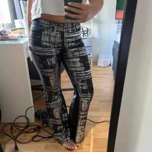 Svarta bootcut byxor med mönster - Utsvängda jeans som jag köpt second hand i Paris. Sparsamt använda så inga defekter. Mid/low waist. Jag är 165 för referens 