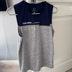 Grå och marinblå träningstopp - Säljer en ärmlös träningstopp från Lowsport i gråmelerat och marinblått. Den är storlek xs💙