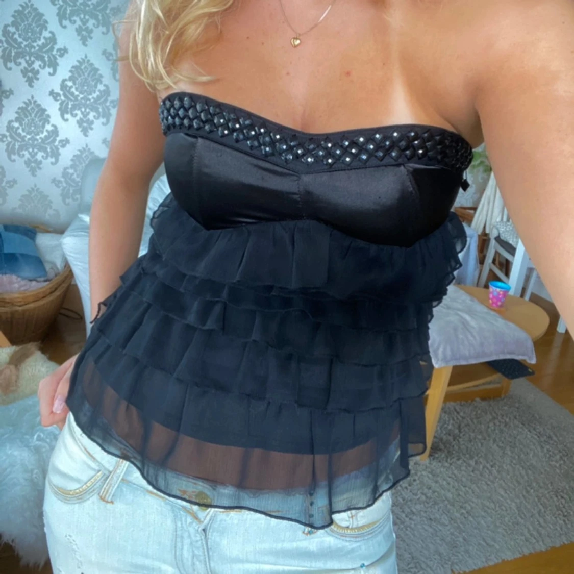 Svart axelbandslös topp med volanger