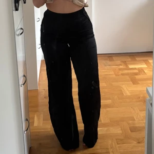 Svarta vida byxor med hög midja - Snygga svarta satin byxor med hög midja och vida ben.