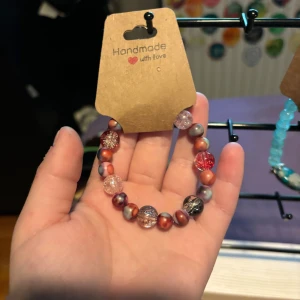 Färgglatt pärlarmband handmade - Unikt armband med pärlor i rött, rosa, silver och grått. Pärlorna är både glittriga och matta, vissa med marmorerad effekt. Perfekt accessoar för dig som vill sticka ut med färg och personlighet.