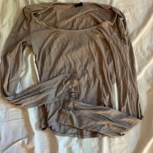 Beige långärmad tröja med slits - En enkel och stilren beige långärmad topp med bred, rundad ringning. Tunt och mjukt material som känns skönt mot huden. Jätte fin