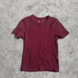 Vinröd ribbad t-shirt från FSBN Sister - Säljer en snygg vinröd ribbad t-shirt från FSBN Sister. Aldrig använd 