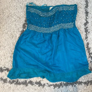 Silkes topp från river island - Säljer denna söta axelbandslösa silkes topp från river island. Fint skick förutom att några ”glitter prickar” har ramlat av. 