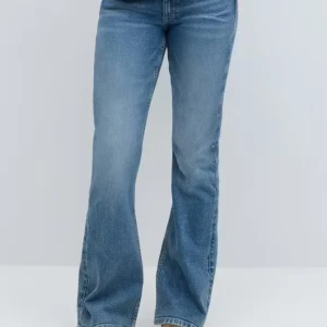 Blå bootcut jeans från Gina Tricot - Säljer ett par klassiska blå bootcut jeans från Gina Tricot. Jeansen har normal passform, två knappar i midjan och snygga fickor både fram och bak. Perfekta för dig som gillar en tidlös jeansstil.