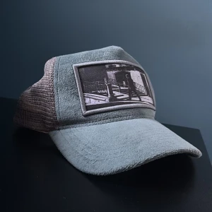 Grå keps från Emilio Pendenza med svartvitt motiv - Säljer en grå keps från Emilio Pendenza med svart mesh på sidorna och ett broderat svartvitt motiv framtill. Kepsen har böjd skärm och justerbar passform. Perfekt accessoar för en cool och avslappnad stil. | obs deffekten ser ni på sista bilden👍🏼 pris kan diskuteras vid snabba köp