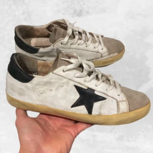 Golden Goose skor vita - Skohylla rensning. •Golden Goose Superstar sneakers mocka captoe. Skick: 8/10, mycket sparsamt använda! Inge som helst heeldrag! Storlek: 40, fits 40-41. Nypris: 6 000 kr~. Äkta givetvis! Medföljer vid köp original box & GGDB skopåse! Hör av dig vid fler frågor eller funderingar, mvh Oliver;) 