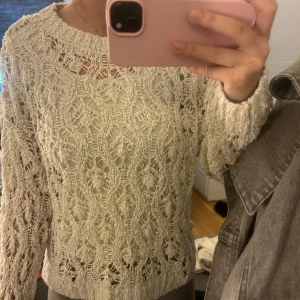 Vit stickad tröja med spetsmönster - Säljer en vit stickad tröja med ett vackert spetsmönster. Tröjan har långa ärmar och en rund halsringning. Perfekt för lager-på-lager-stil. Passar om man har storlek xs/s.