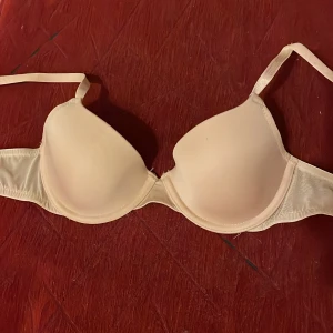 Beige bh från HM - Säljer en beige bh med mjukt tyg och justerbara axelband. Den har en slät design och ger bra stöd. Perfekt för daglig användning, storlek 75A från HM.