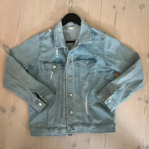 Ljusblå jeansjacka med slitningar - Säljer min ljusblåa jeansjacka med slitna detaljer och knappar framtill. Aldrig använt den själv då jag precis köpt den på Vinted. Passade mig inte så därför säljer jag. Hör av er vid frågor!💗💗
