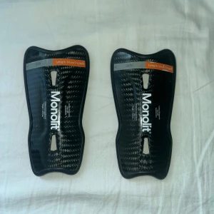 Monolit benskydd 14cm  - Här är ett par fräscha monolit benskydd i toppkvalitet! De finns inte ett par bättre benskydd på marknaden just nu. Skicket är 9/10 då jag slutade på fotboll och hann knappt använda de. För mer info eller bilder så kan du höra av dig till mig! 