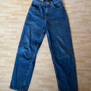 Blå 90's Baggy jeans från H&M - Säljer ett par blå 90's Baggy jeans från H&M hög midja. Jeansen har en lös och rak passform. De är i storlek 36 och i mycket bra skick.