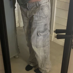 Grå cargobyxor från Bershka - Snygga grå cargobyxor från Bershka Byxorna har en loose passform. Säljer dom för de är för stora för mig som vanligtvis har stl 36 i jeans. Dessa är i storlek 38😍🫶