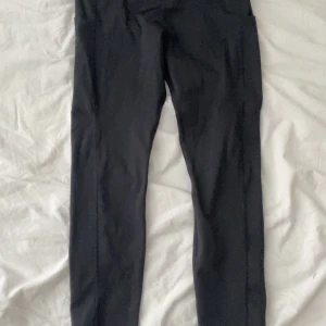 Svarta träningstights Energetics S - Svarta träningstights från Energetics i storlek S. Tillverkade i ett stretchigt syntetmaterial med DRY PLUS-teknologi som håller dig torr under träningspasset. Tightsen har en tight passform och är perfekta för gymmet eller löprundan.