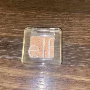 e.l.f. glitterögonskugga White Hot - Helt nytt Glittrig ögonskugga från e.l.f. i färgen White Hot. Kommer i en smidig, transparent plastförpackning med lock. Skuggan har en ljus, champagnefärgad ton med massor av shimmer som ger en snygg glansig finish.