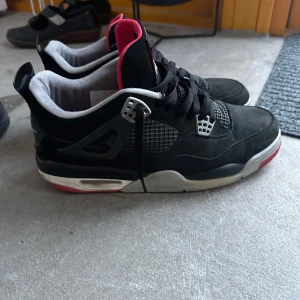 Nike Air Jordan 4 Black/Red sneakers - Säljer ett par Nike Air Jordan 4 i svart mocka med röda och grå detaljer. Väldigt bra skick 