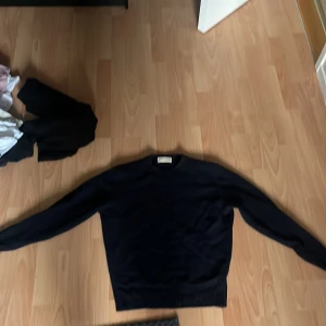 Mörkblå stickad tröja Studio de L'Artisan - En stilren mörkblå stickad tröja från Studio de L'Artisan. Tröjan har rund halsringning, ribbade muddar och är långärmad. Perfekt för lager-på-lager och funkar till många olika outfits. Klassisk och enkel design som aldrig går ur tiden. Jag är 175 på bilden, den passar mellan 170-175 nypris 2500, pris kan diskuteras, Ni får supperrabbat om ni köper mer än ett plagg av mig