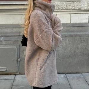 Beige teddyjacka med dragkedja - Supermjuk och oversized teddyjacka i beige med hög krage och dragkedjor i sidorna. Jackan har lång ärm och är tillverkad i fluffigt fleece-material. Endast använd ett par gånger. 