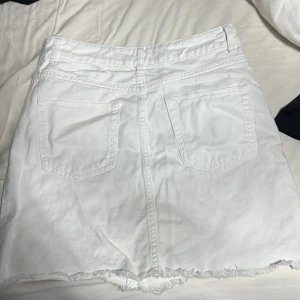 Vita jeansshorts från Even&Odd - Snygga vita jeansshorts från Even&Odd med hög midja och råa, fransiga kanter. Shortsen har klassiska fem fickor, dragkedja och knapp framtill samt slitna detaljer för en cool look. Perfekta för sommardagar och festivaler.