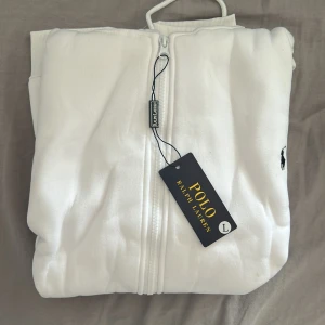 Vit zipjacka från Polo Ralph Lauren - Vit zipjacka från Polo Ralph Lauren med klassisk broderad logga på bröstet. Jackan har hel dragkedja framtill. Perfekt för en clean och stilren look.( vet ej om de äkta)