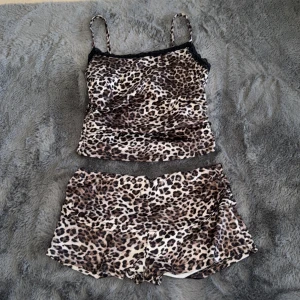 Leopardmönstrad linnetopp med spets - Säljer en leopardmönstrad linnetopp med tunna axelband och svart spetskant upptill. Toppens material är mjukt och glansigt, perfekt för en trendig look. Jätteskönt att ha hemma 