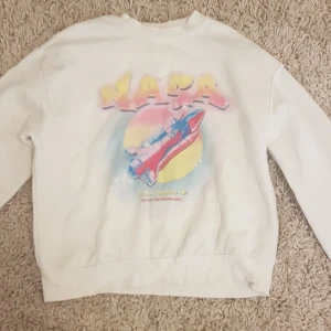 Vit NASA sweatshirt med rymdmotiv - Vit sweatshirt med färgglatt NASA-tryck och rymdfärja på framsidan. Tröjan har rund hals, långa ärmar och mjuk insida i fleece. Perfekt för dig som gillar space vibes och streetstyle. PRIS KAN DISKUTERAS!