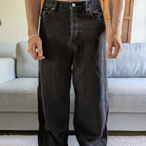 Weekday Astro Loose Baggy Jeans svart - Svarta Weekday Astro Loose Baggy Jeans med riktigt bred passform. Jeansen är tillverkade i bomull. Klassisk femficksmodell och grov denimkänsla.