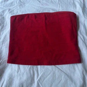 Röd tubtopp från Hollister XS - Enkel och snygg röd tubtopp från Hollister i storlek XS. Modellen är ärmlös, perfekt för varma dagar eller lager på lager. Något liten i storleken