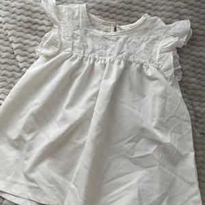 Vit blus - Vit blus med volang och små blommor!