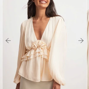 Beige blus med volanger  - Säljer denna fina blus från NA-KD som tyvärr inte kommer till användning. Endast använd 1 gång!☺️