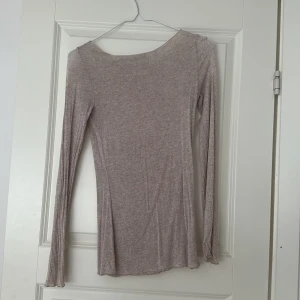 Beige långärmad topp från Intimissimi - Supermjuk och tunn beige långärmad topp från Intimissimi, tillverkad i en mix av kashmir och bomull. Modellen är figurnära med rundad hals och har en lätt melerad look. Säljer den då jag inte använder den längre. Har tyvärr några små skador på ärmarna då jag har fastnat i något och trådarna hängt med lite. Annars är materialet som nytt. 