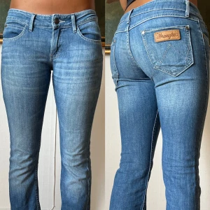 Blå bootcut jeans från Wrangler - Snygga ljusblå bootcut jeans från Wrangler med klassisk femficksdesign och logga på bakfickan. Jeansen har låg midja och är tillverkade i mjukt denimtyg som sitter skönt. Perfekta för dig som gillar en tidlös och avslappnad look.