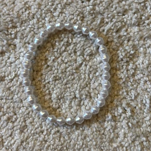 Set med pärlarmband i vitt och guld - Tre elastiska armband med oregelbundna vita pärlor och små guldfärgade pärldetaljer. Armbanden har en fräsch och trendig look, perfekta att mixa och matcha. Passar dig som gillar en stilren men ändå lekfull accessoar. 10kr st. OBS!!!! KOMMER GÖRA RENT INNAN SICKAD