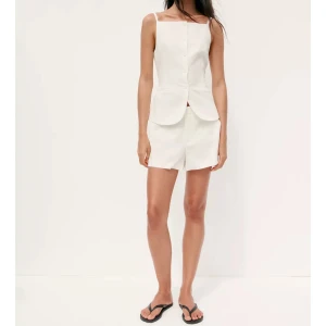 Vita midwaist shorts från Zara - Snygga vita shorts från Zara med midwaist-passform och raka ben. De har diskreta sidfickor och stängs med dragkedja fram. Perfekta för varma dagar och ger en clean och fräsch look. Materialet är mjukt och lätt, vilket gör dem superbekväma. Riktigt snygga och passar perfekt för alla tillfällen!! 💋🌸🤩😍 Lapp borttagen, aldrig andvända. (Linne) 