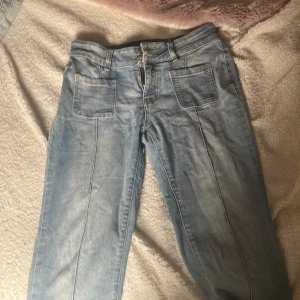 Ljusblå jeans från Madlady, strl 38 - Säljer ett par ljusblå jeans från Madlady i storlek 38 short. Jeansen har raka ben, stora fickor fram och bak med knappdetaljer, samt klassisk jeanssöm. Perfekta om du gillar ljusare jeans 