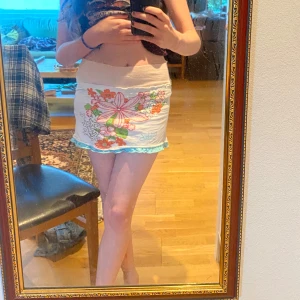 Vit blommig minikjol från Billabong - Supersöt vit minikjol från Billabong med blommor framtill som jag sytt själv från ett barn linne, stretching material.