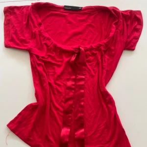 Röd topp med knyte från KappAhl XS - Röd topp från KappAhl i storlek XS med korta ärmar och snygg knytning framtill. Sååå fin