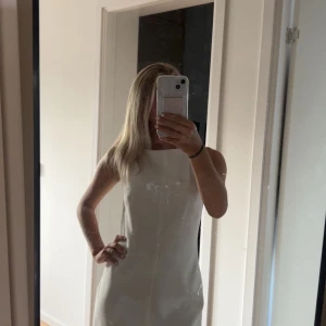 Vit ärmlös kortklänning - En vit fin kort klänning från Zara. Den är i storlek S och säljer då jag vanligt vis är i storlek xs och den är lite för stor. Jätte snygg med vita smala band upptill. Den är helt ny utan prislapp och jag har aldrig använt den. 