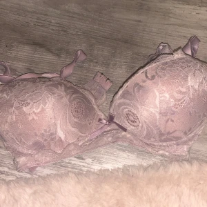 Ljuslila spetsig korsett-topp - Supersöt ljuslila korsett-topp med vadderade kupor och vackra spetsdetaljer. Dekorerad med små rosetter och justerbara axelband. Perfekt för att ge outfiten en romantisk vibe. Snyggt mönstrad spets och mjuk insida för extra komfort.