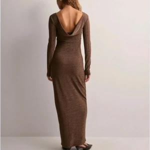 Brun glittrig långklänning med öppen rygg - Supersnygg brun långklänning med glittrigt tyg. Aldrig använd, prislappen är kvar på!