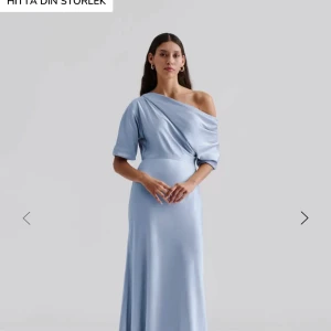 Ljusblå långklänning med oneshoulder - Säljer här min super fina ljusblåa balklänning i satin. Klänningen har en snygg oneshoulder-design med kort ärm på ena sidan och en slät, figurnära passform som faller mjukt längs kroppen. Klänningen är ifrån Malina och jag köpte den för 3600 kr, använd en gång och ser ut som ny💙
