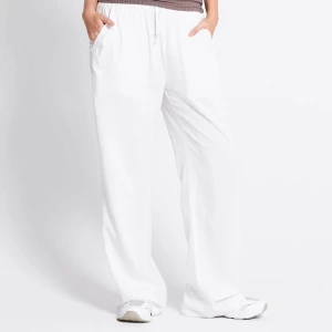 Vita vida linnebyxor med snörning - Säljer ett par vita linnebyxor med avslappnad passform och breda ben. Byxorna har resår och snörning i midjan samt fickor på sidorna och en bakficka. Perfekta för en chill och stilren look. Aldrig använda🩷