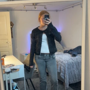 Svart kofta från Gina Tricot - Mysig svart kofta från Gina Tricot med rund halsringning och knappar framtill. Koftan är stickad och har långa ärmar, perfekt att slänga över en topp. Enkel och stilren design som funkar till många outfits.