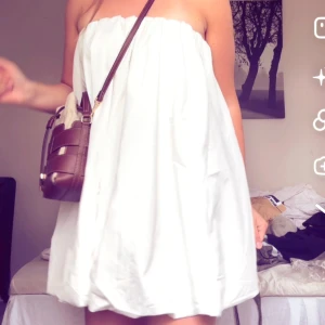 Vit voluminös kort klänning - Superfin vit kort klänning med voluminös ballongform och avtagbara tunna axelband. Klänningen är axelbandslös när banden tas bort och har ett snyggt rynkat fall. Perfekt för dig som vill sticka ut med en modern och luftig look. Superfin till sommaren!❤️ Helt ny med prislapp kvar!🥰