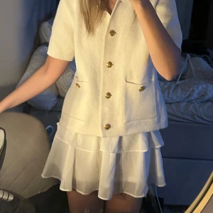 Vit volangkjol med resårmidja - Söt vit kjol med volanger och stretchig resår i midjan. Skön och passar till allt! Väldigt bra skick och går att ha som lågmidjad och vanligt då man kan vika ned resåren. 💕