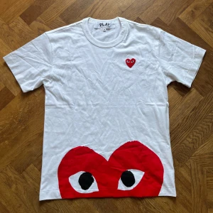 CDG Play T-shirt - Comme Des Garçons Play T-shirt med röda hjärtan, mycket fint skick, använd typ 2 gånger. Inga hål eller fläckar.  Hör av dig vid frågor eller fler bilder!