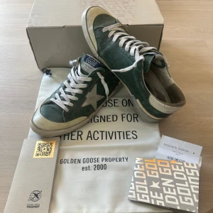 Gröna sneakers från Golden Goose - Snygga gröna sneakers från Golden Goose med vit stjärndetalj på sidan, vita snören och slitna detaljer för en cool vintage-look. Skorna har rund tå, platt sula och är tillverkade i skinn. Allt og kvitto box dustbag, hyfsat skick mycket kvar att ge med en unik och eftertraktad design.