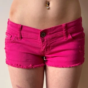 Rosa Lågmidjade jeansshorts hollister minishorts lowwaist  - Från hollister. Står ingen storlek men passar xs-s. Shortsen har resår bak som ”töjs” när de bärs. Midjemått när resåren är utsträckt:36-38. Shortsen är lite mindre lysande rosa i verkligheten. Köp sker via köp nu. Jag postar inom 24h. Kvar tills markerad såld