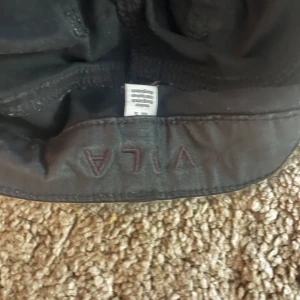 Svarta bootcut- läderbyxor  - Snygga svarta bootcut-läderbyxor från Vila.